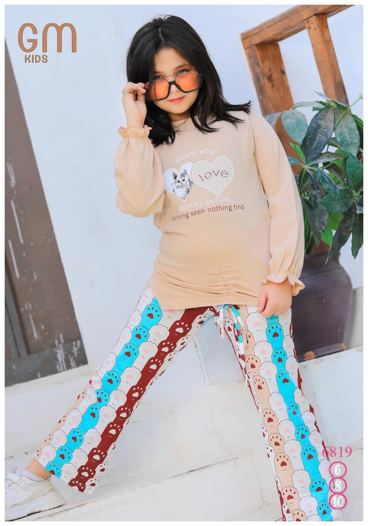 Child wearing a beige long-sleeve shirt and colorful pants with sunglasses, standing on steps.