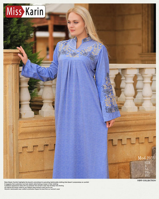 Woman wearing a blue embroidered dress standing outdoors with 'Miss Karin' branding.