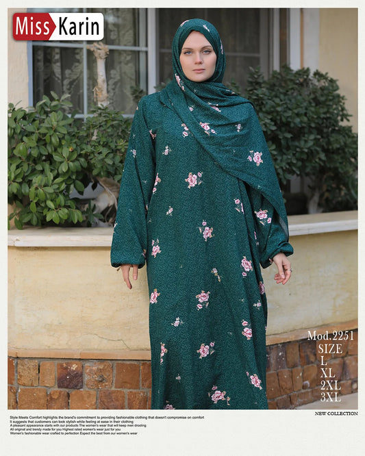 Woman wearing a green floral dress and hijab outdoors with 'Miss Karin' branding.