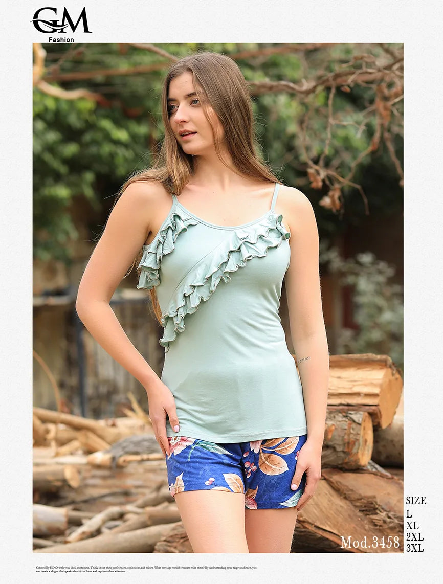 Woman wearing a light blue ruffled top and floral shorts outdoors