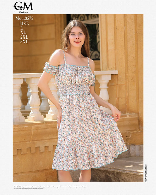 Woman wearing a floral dress standing outdoors with a stone wall and columns in the background.