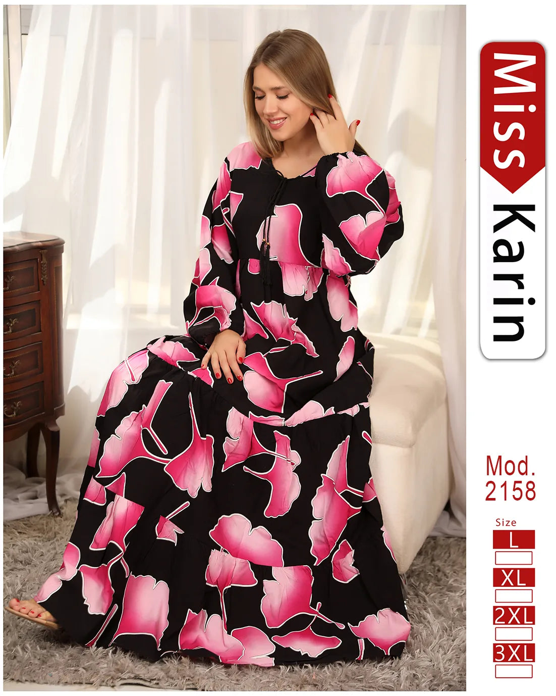 Woman wearing a black dress with pink floral patterns, sitting on a white couch. 'Miss Karin' brand visible.