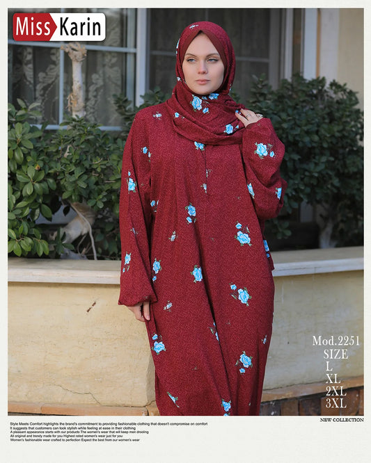 Woman wearing a red dress with floral patterns outdoors, branded 'Miss Karin'.