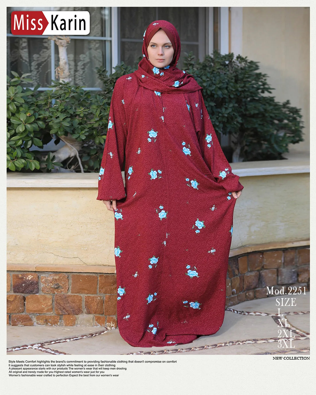Woman wearing a red dress with floral patterns in front of a building with plants.