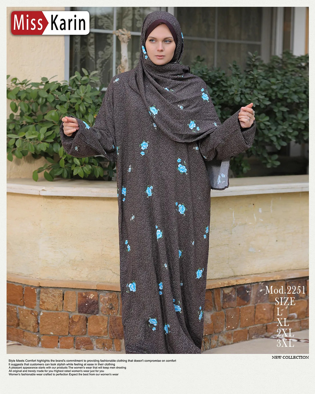 Woman wearing a dark gray dress with blue floral patterns, standing outdoors.