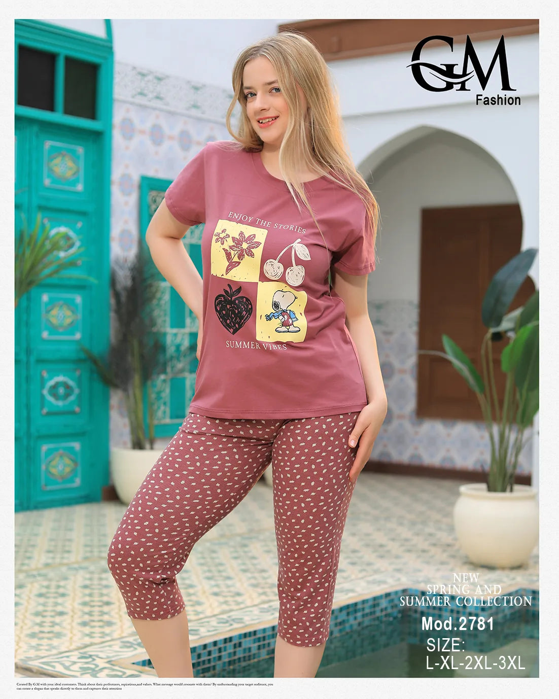 Woman wearing a pink t-shirt with graphics and patterned pants in front of a decorative building.