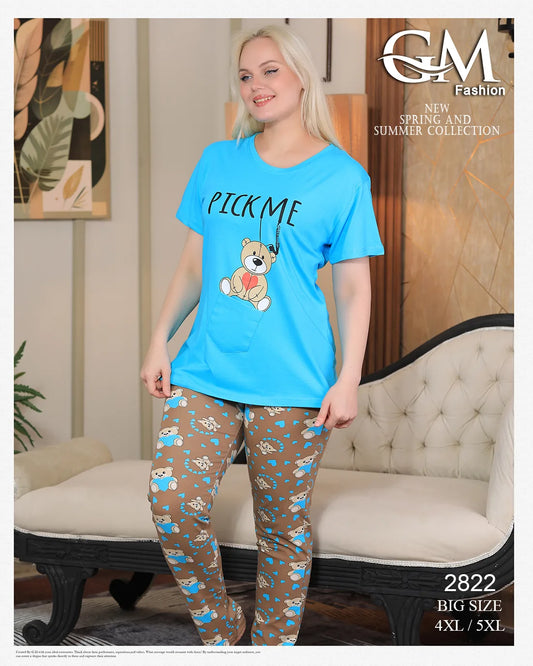 Woman wearing a blue t-shirt with a teddy bear graphic and patterned pants in a room setting.