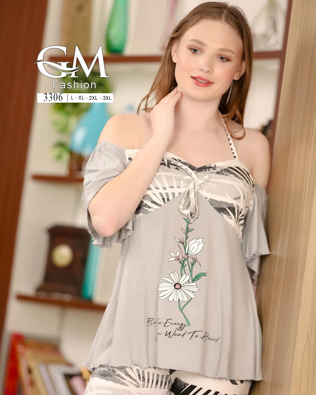 Woman wearing a floral off-shoulder top with a blurred indoor background