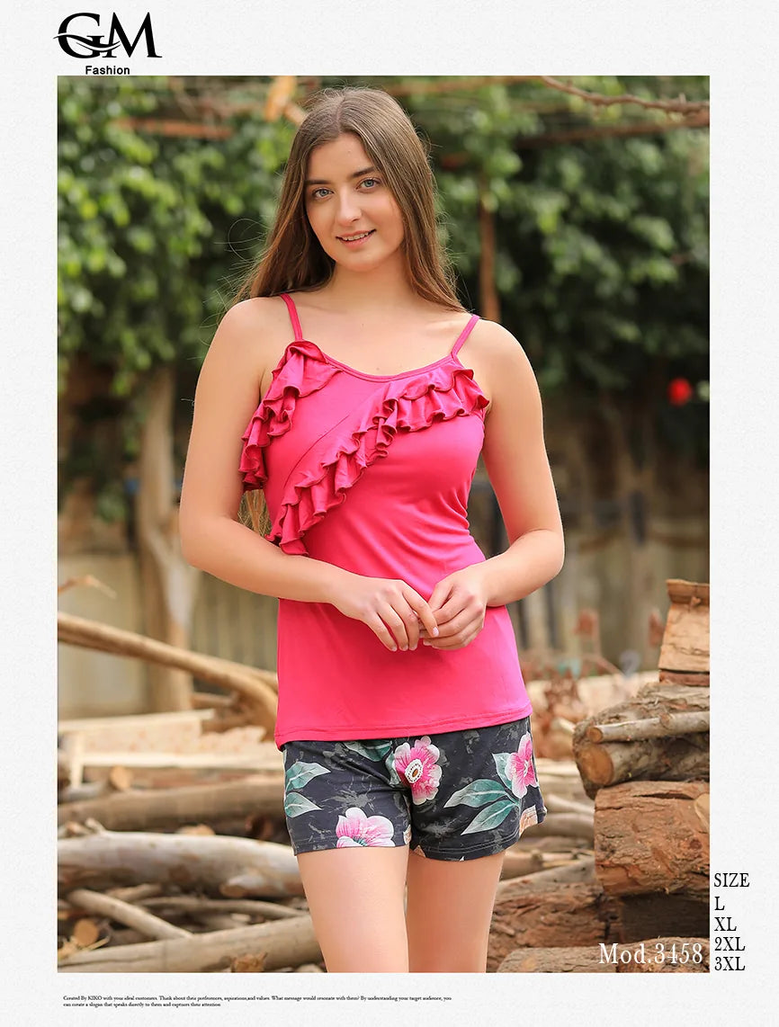 Woman wearing a pink ruffled top and floral shorts outdoors
