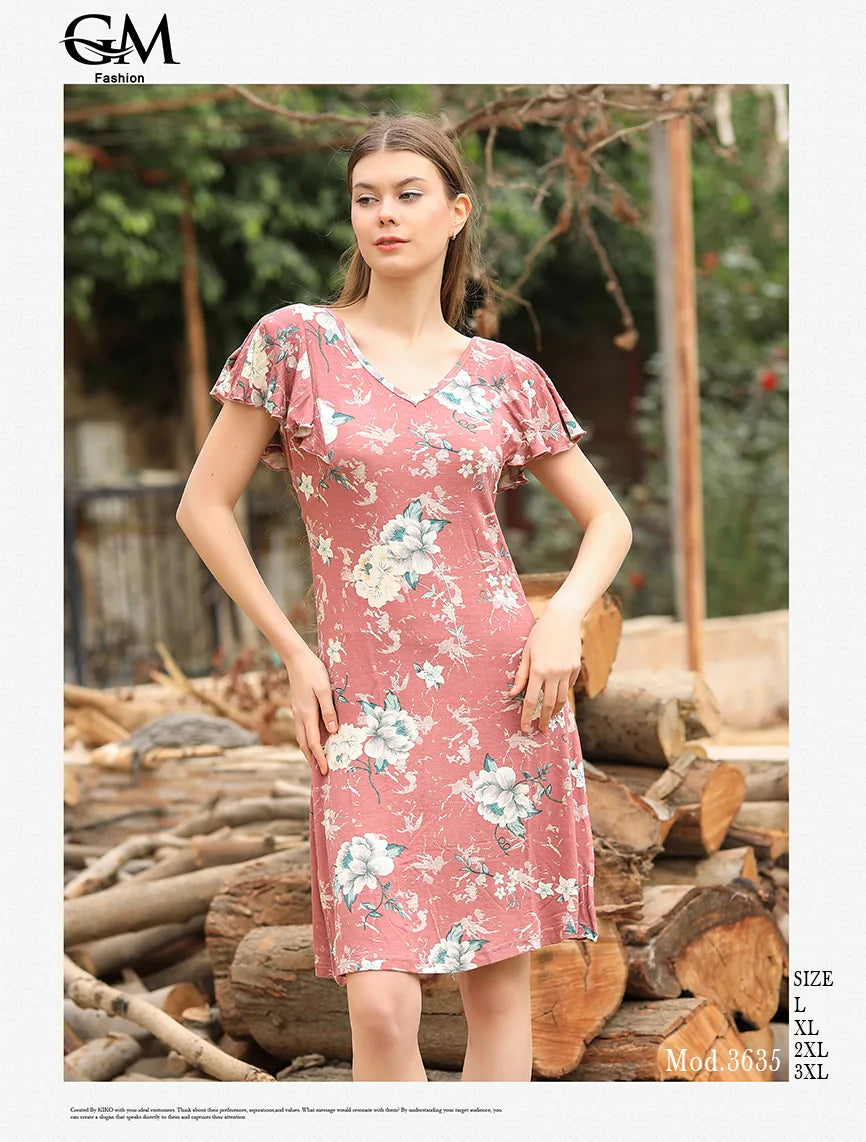 Woman wearing a floral dress standing in front of stacked logs with 'G&M Fashion' branding.