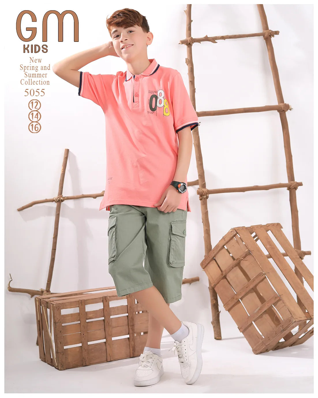 Young boy wearing a pink polo shirt and green shorts standing next to wooden crates and a ladder.