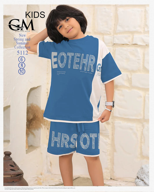 Child wearing a blue and white outfit with text, standing against a light-colored wall.