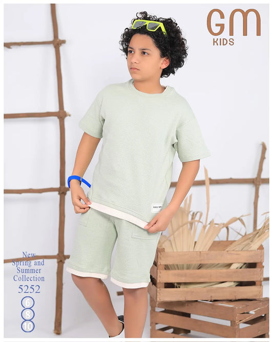 Child wearing a light green outfit with 'GM Kids' branding in the corner.