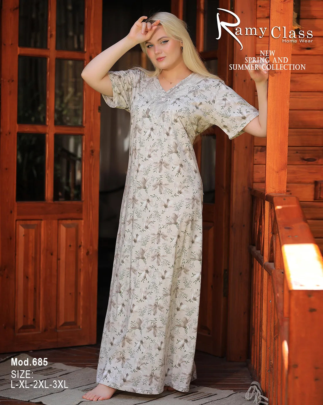Woman wearing a long floral dress in front of a wooden door.