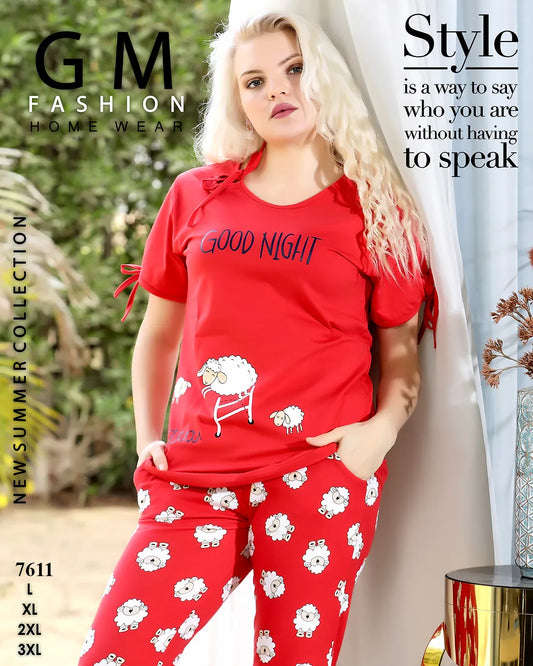 Woman wearing a red 'Good Night' pajama set with sheep design, standing in a home setting.