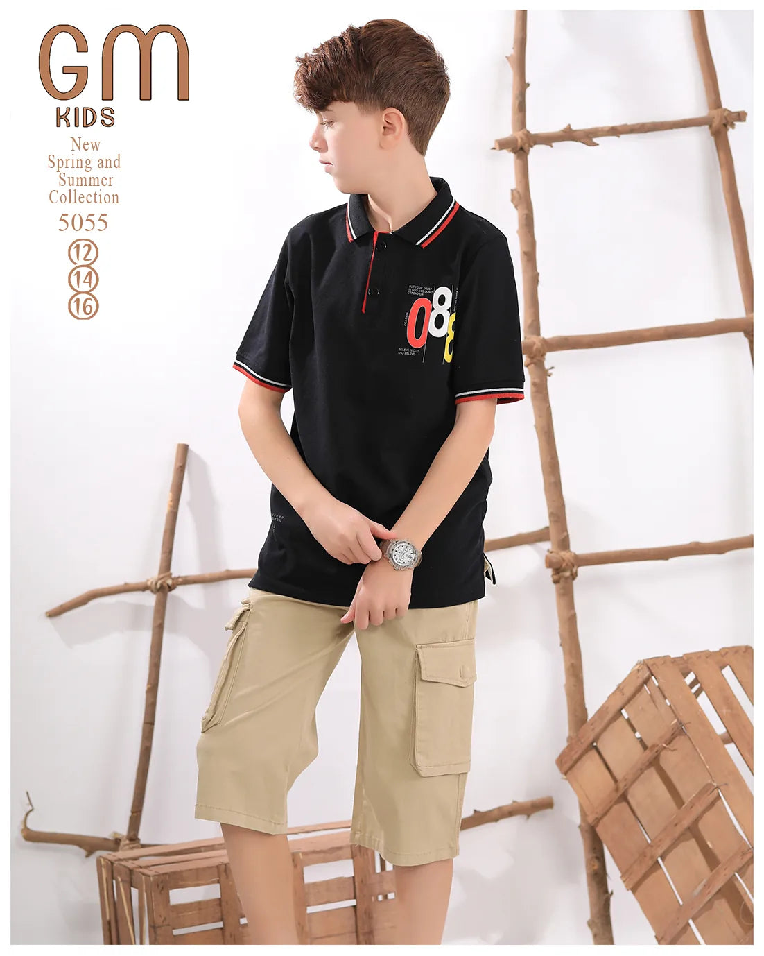Young boy wearing a black polo shirt with colorful design and beige cargo shorts, standing against a white background with wooden elements.
