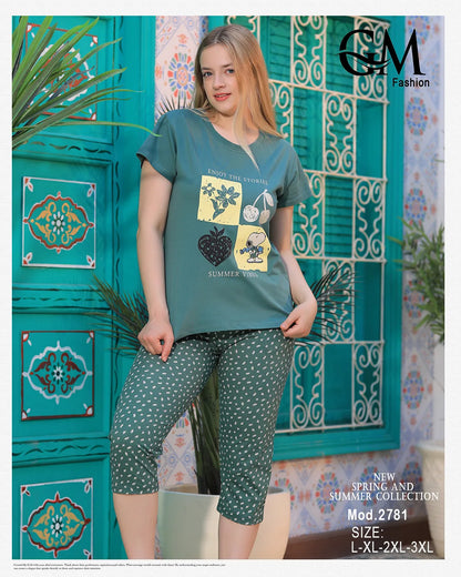 Woman wearing a green t-shirt and patterned pants against a decorative blue wall.