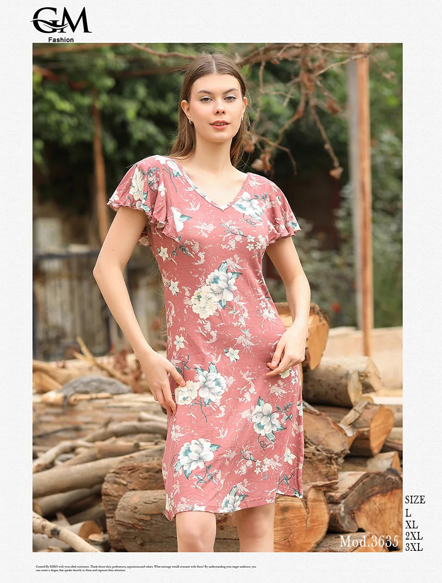 Woman wearing a pink floral dress standing in front of stacked logs.