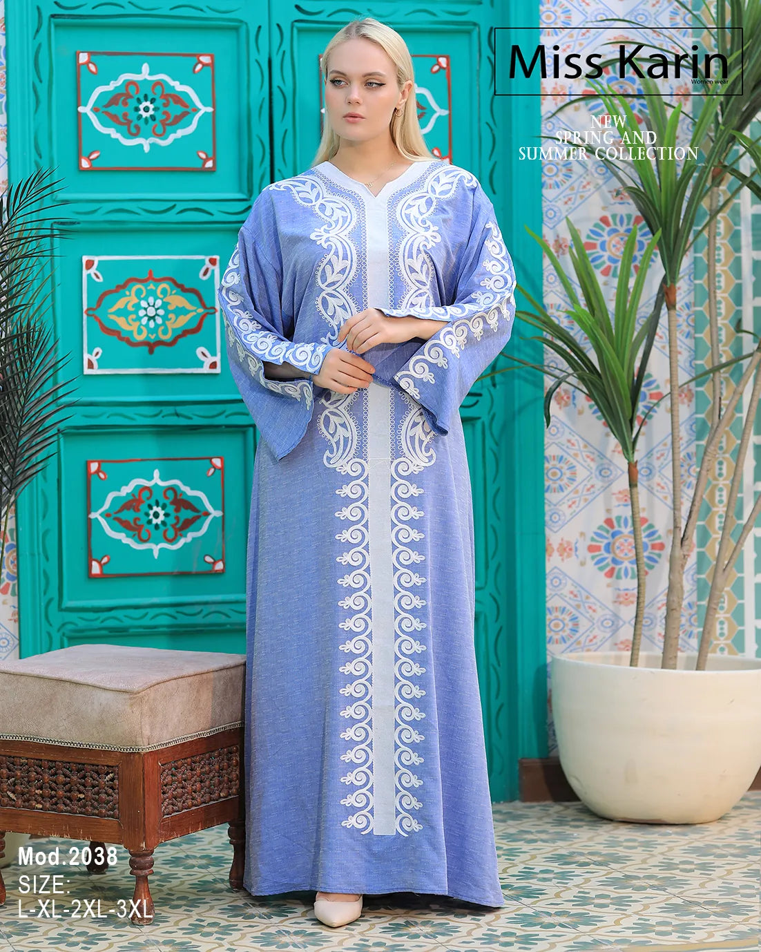 Woman wearing a blue embroidered dress with a decorative green wall in the background, featuring 'Miss Karin' branding.