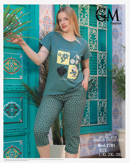 Woman wearing a green t-shirt and patterned pants against a decorative blue wall.