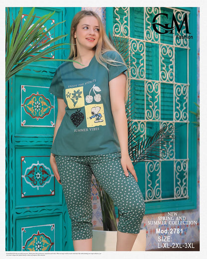 Woman wearing a teal t-shirt and patterned shorts in front of a decorative blue wall.