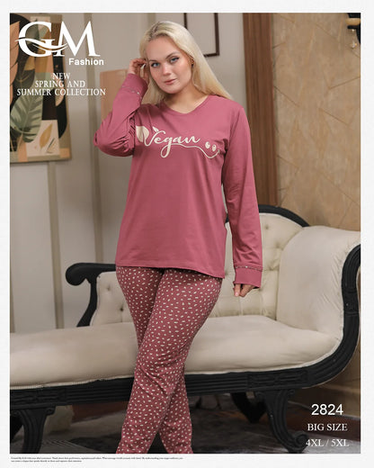 Woman wearing pink 'Vegan' top and patterned pants in a room with a couch.