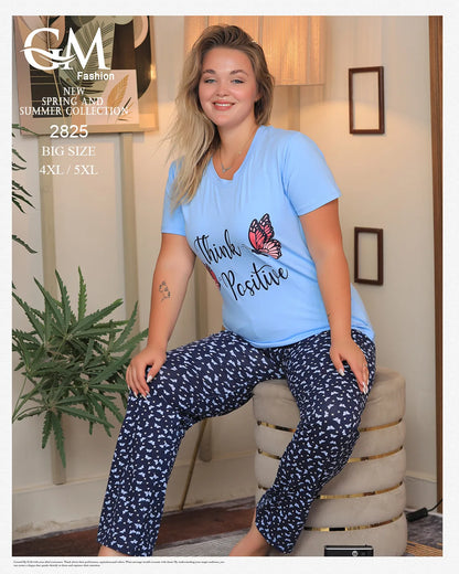 Woman wearing a blue 'Think Positive' t-shirt and navy patterned pants sitting on a chair.