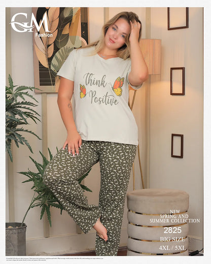 Woman wearing a 'Think Positive' t-shirt and patterned pants in a home setting with decor elements.