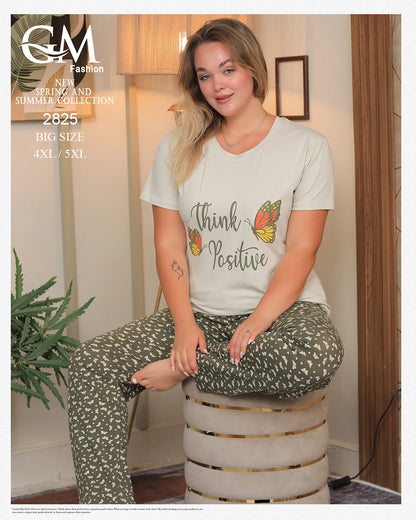 Woman wearing a 'Think Positive' t-shirt sitting on a stool indoors.