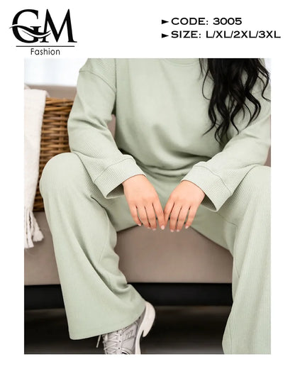 Person wearing a light green outfit sitting on a couch with 'GM Fashion' branding.