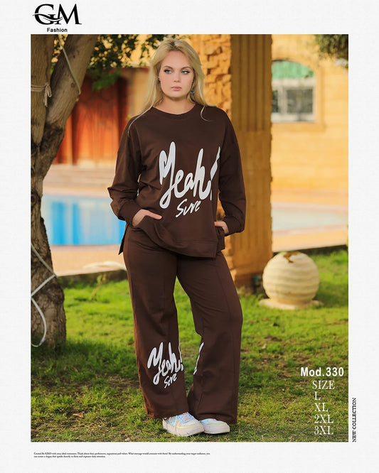 Woman wearing a brown tracksuit with 'Yeah Sure' text in an outdoor setting, featuring the brand 'GM Fashion'.