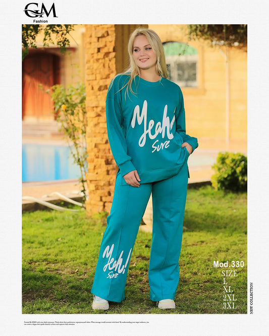 Woman wearing a teal outfit with 'Meah Sure' text, standing outdoors.