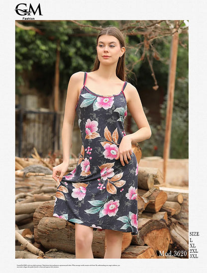 Woman wearing a floral dress standing among logs with 'G&M Fashion' branding.