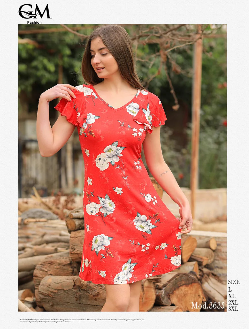 Woman wearing a red floral dress standing outdoors with logs in the background