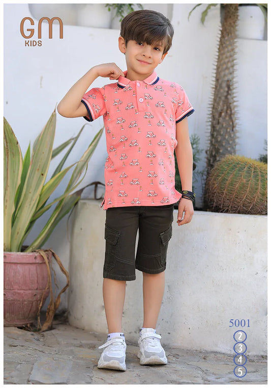 Child wearing a pink shirt with black patterns and dark shorts outdoors.