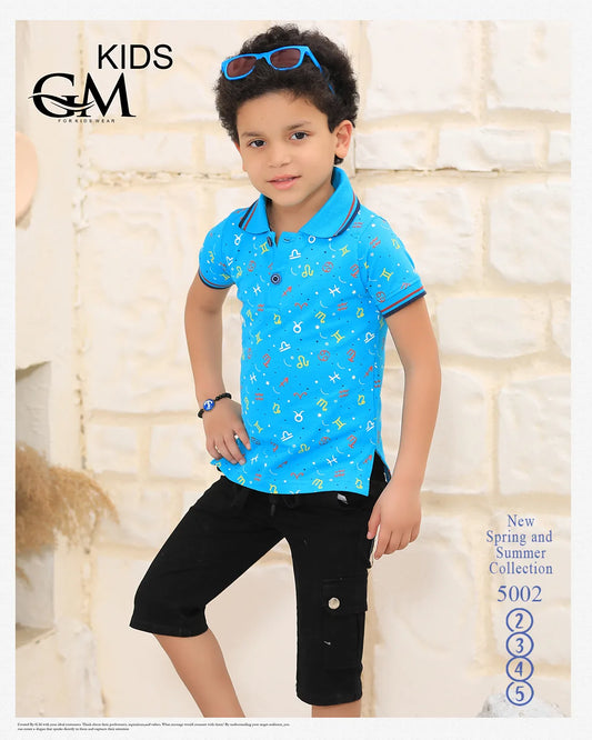 Child wearing a blue polo shirt with colorful patterns and black shorts against a stone wall.