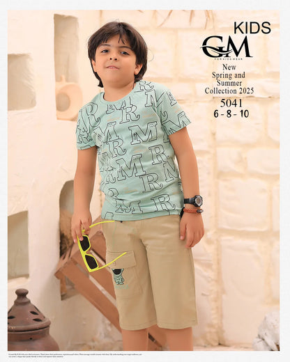 Child wearing a light blue t-shirt with letter pattern and beige shorts, holding sunglasses, against a neutral background.