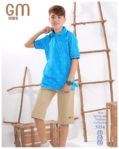 Child wearing a blue patterned shirt and beige shorts standing against a white background with wooden ladder and crate.