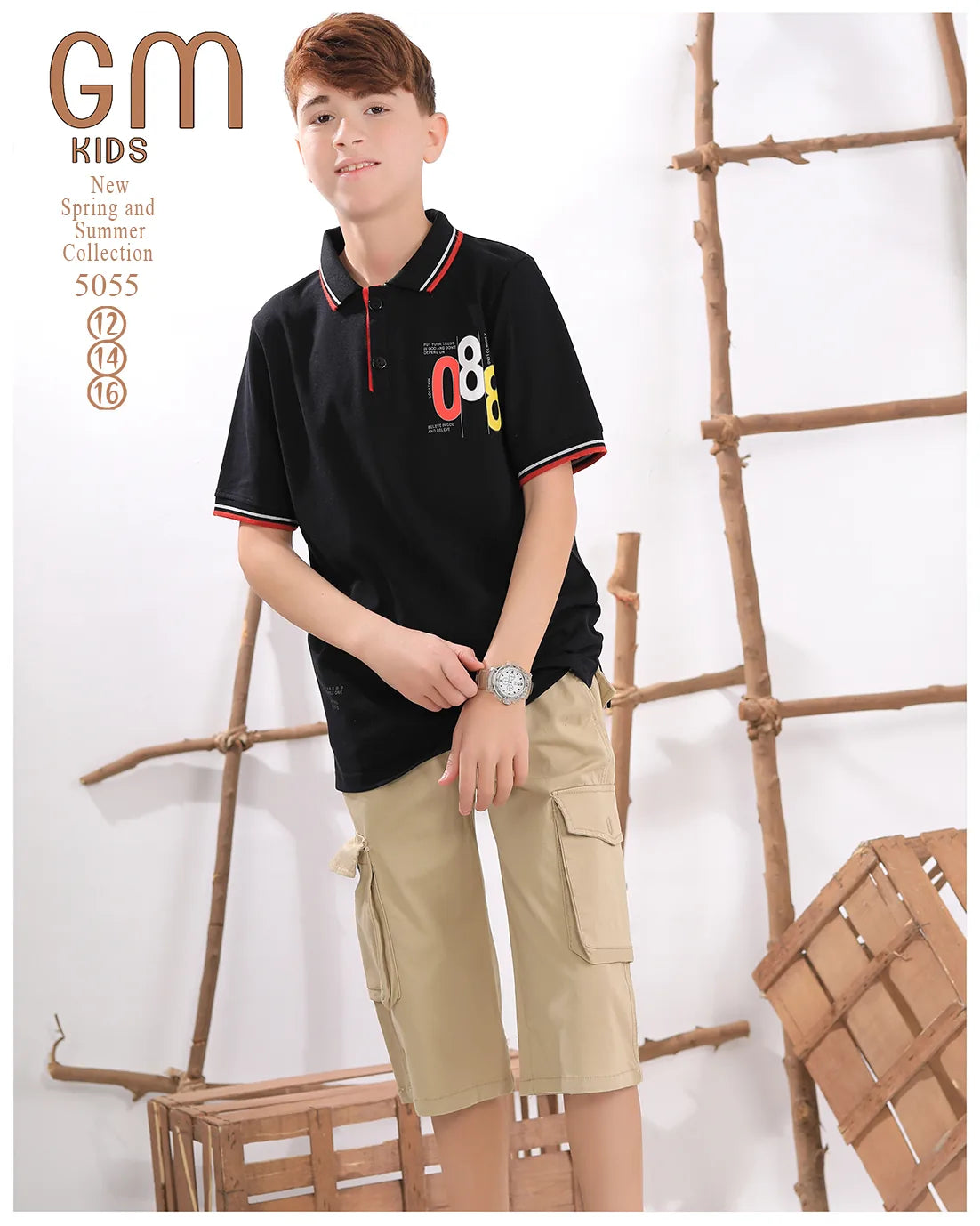 Young boy wearing a black polo shirt with colorful design and beige cargo shorts, standing against a white background with wooden elements.
