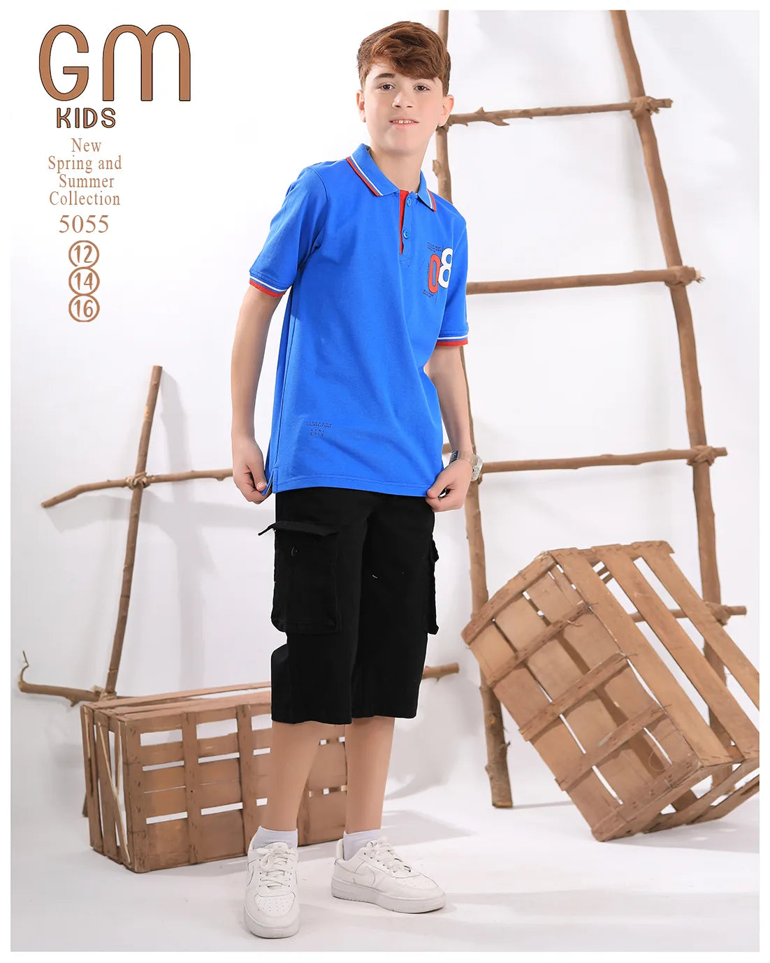Child wearing a blue polo shirt and black shorts standing in front of wooden crates and a ladder.