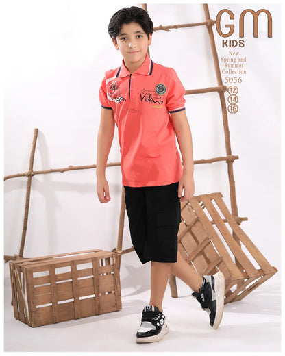 Child wearing a pink polo shirt with brand logo, black shorts, and sneakers against a white background with wooden crates.
