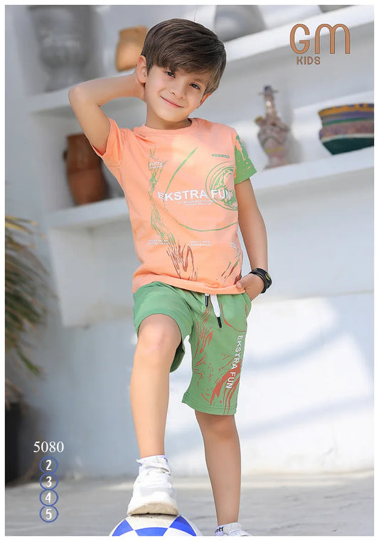 Child wearing an orange shirt and green shorts with 'Extra Fun' text, standing on a blue and white object.