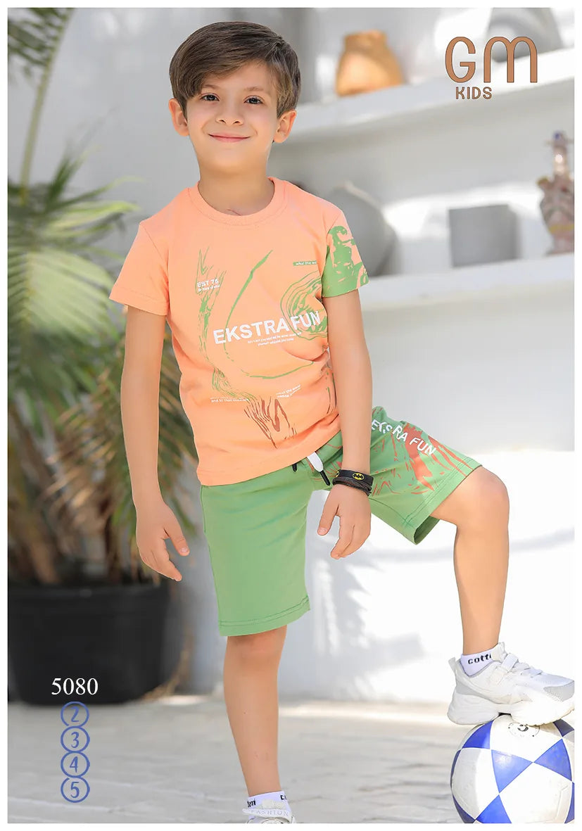 Child wearing an orange and green outfit with 'Ekstra Fun' text, standing on a ball indoors.