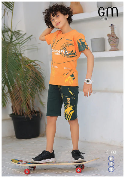 Child wearing an orange and green outfit with 'EXTREME FUN' text, standing on a skateboard indoors.
