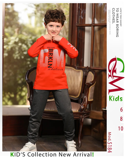 Child wearing a red sweatshirt with text, standing in a room with furniture.
