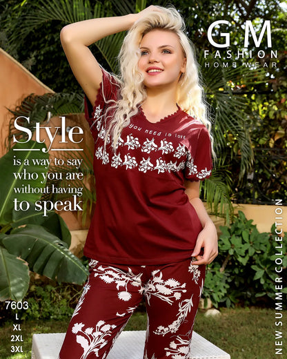 Woman wearing a red floral outfit with 'GM Fashion' branding in a garden setting.