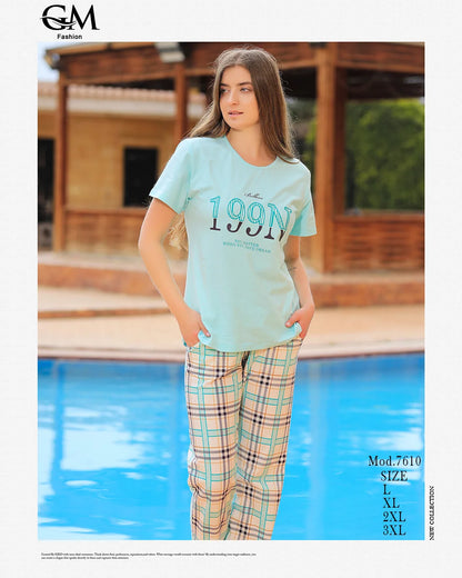 Woman wearing a light blue t-shirt with text and plaid pants by a pool, with 'GM Fashion' branding.