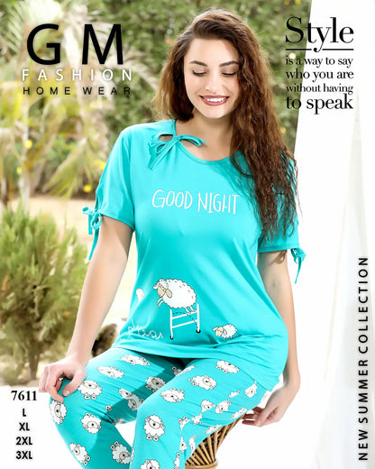 Woman wearing teal 'Good Night' pajama set with sheep design, standing outdoors.