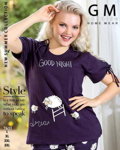 Woman wearing a purple 'Good Night' t-shirt with sheep designs, standing indoors.