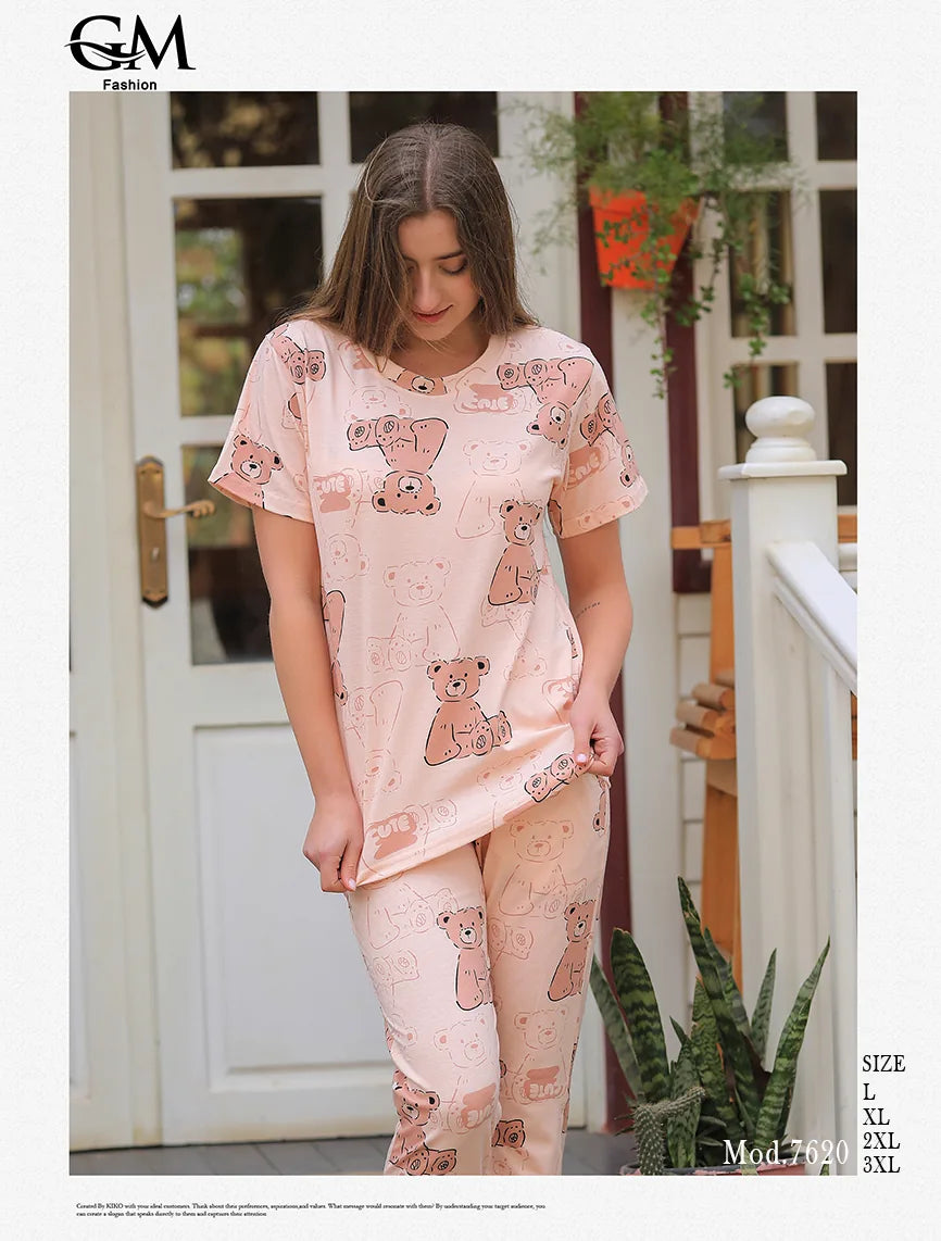 Woman wearing a pink pajama set with teddy bear pattern outdoors.